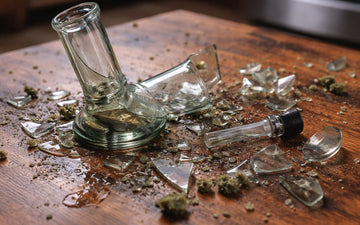 Broken glass bong on wooden table