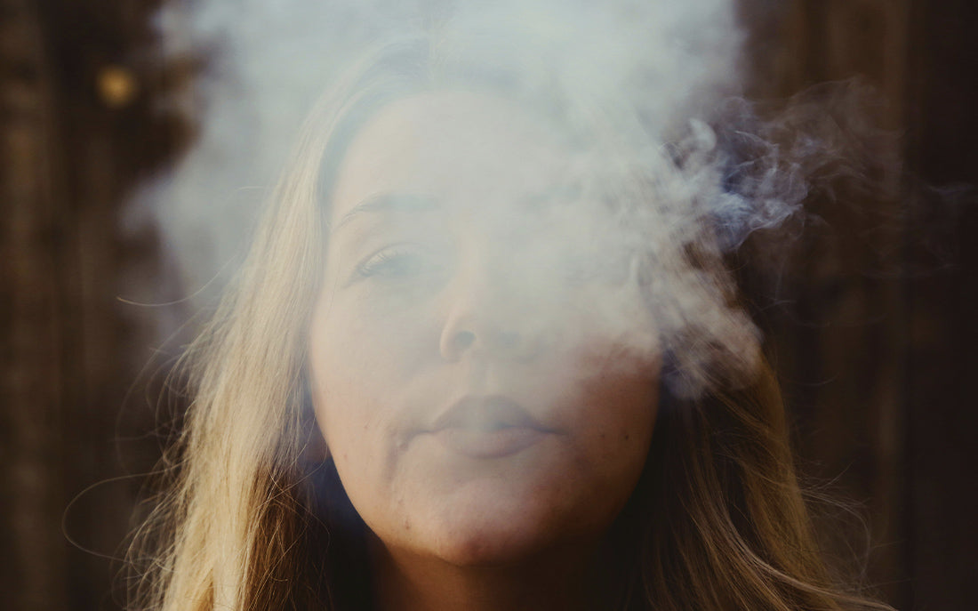 Woman exhaling large bong hit