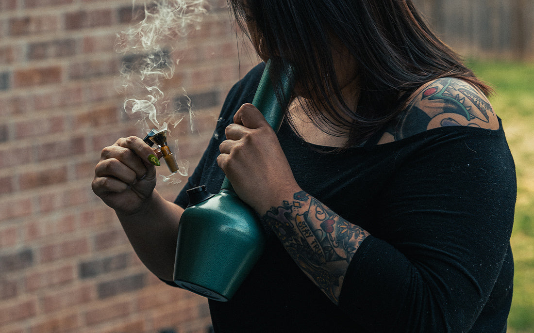 Woman taking big rip out of gree bong Chill Steel Pipe