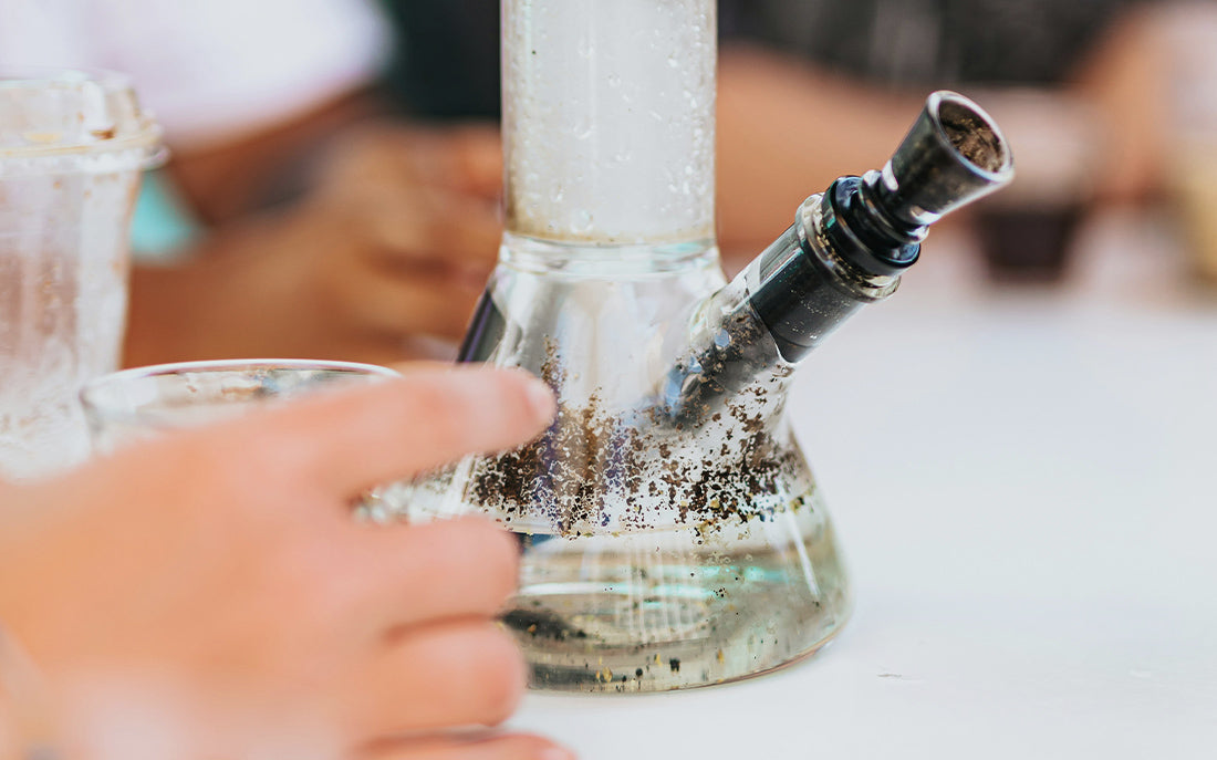 Bong with water and residue in focus