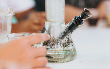 Bong with water and residue in focus