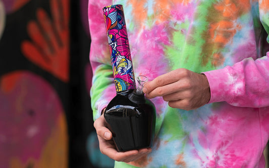 Colorful bong held by individual in tie-dye shirt