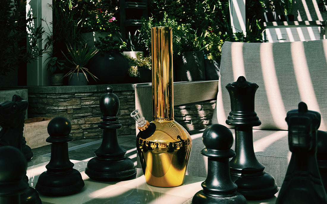Golden bong next to chess pieces