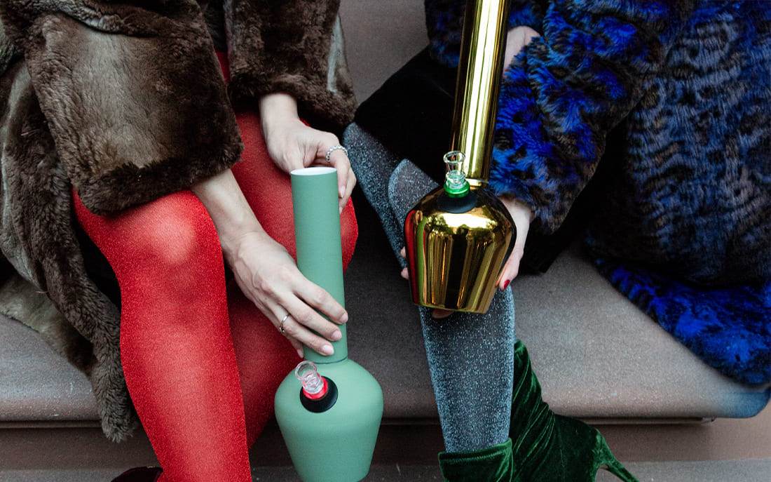 Fashionable women holding modern bongs outdoors