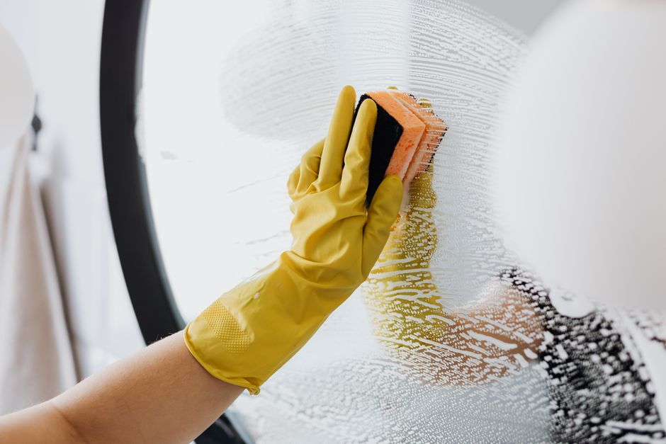 Cleaning glove with sponge and soap on the mirror