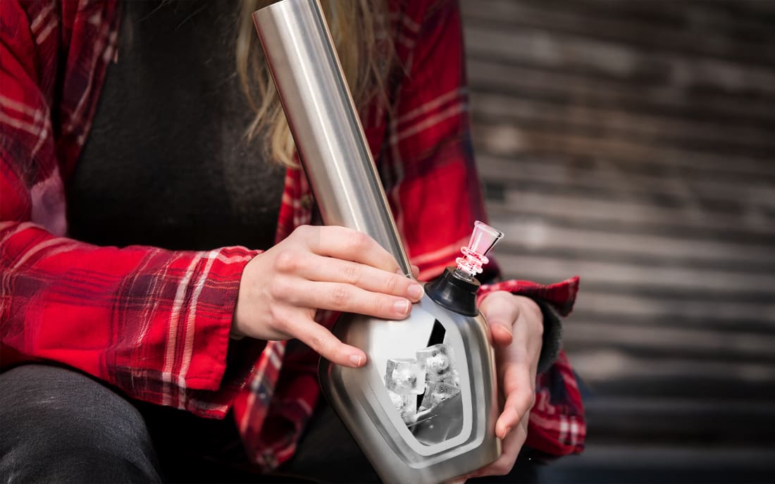 Person holding a metal bong with ice