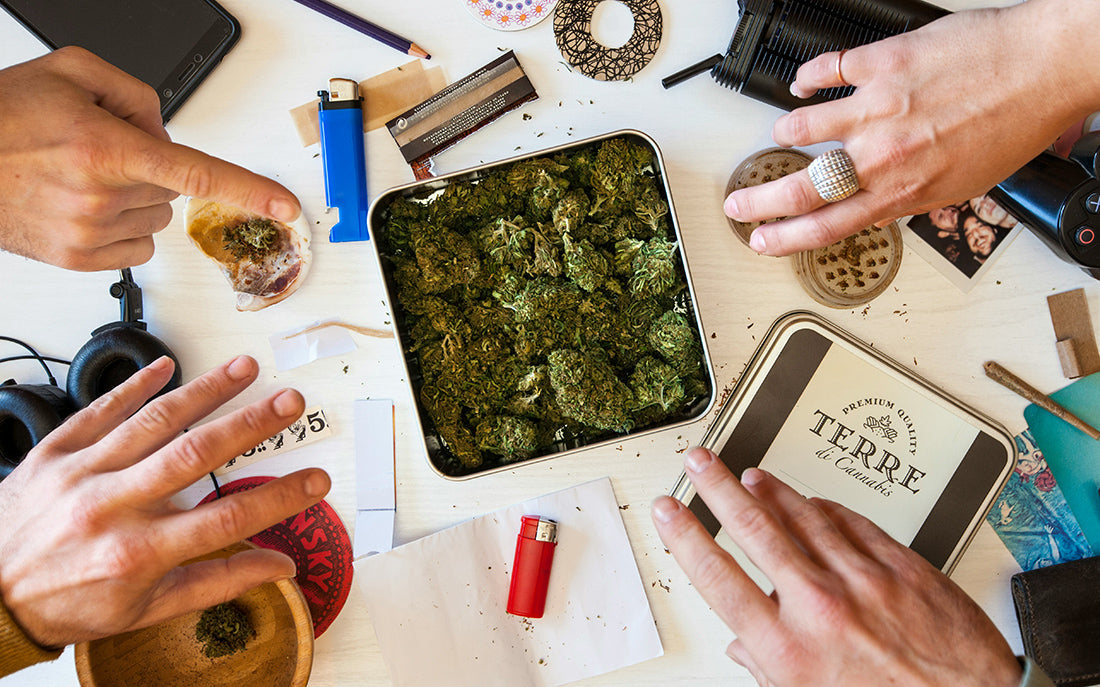 Rolling paper, grinder, and herbs on table