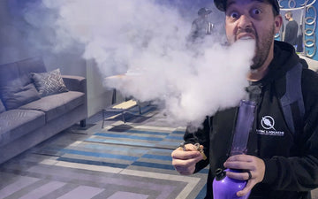 Man exhaling smoke from bong