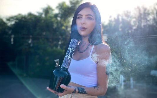 Person holding smoke-emitting item outdoors