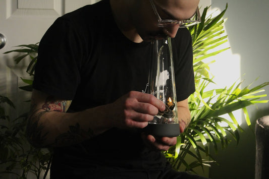 Person using a glass bong indoors